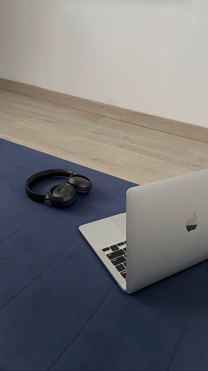 Laptop en koptelefoon op een Pilates mat